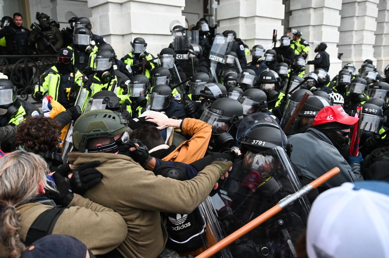 Riot police push back a crowd of supporters of then-President Donald Trump after they stormed the Capitol building on January 6, 2021.
