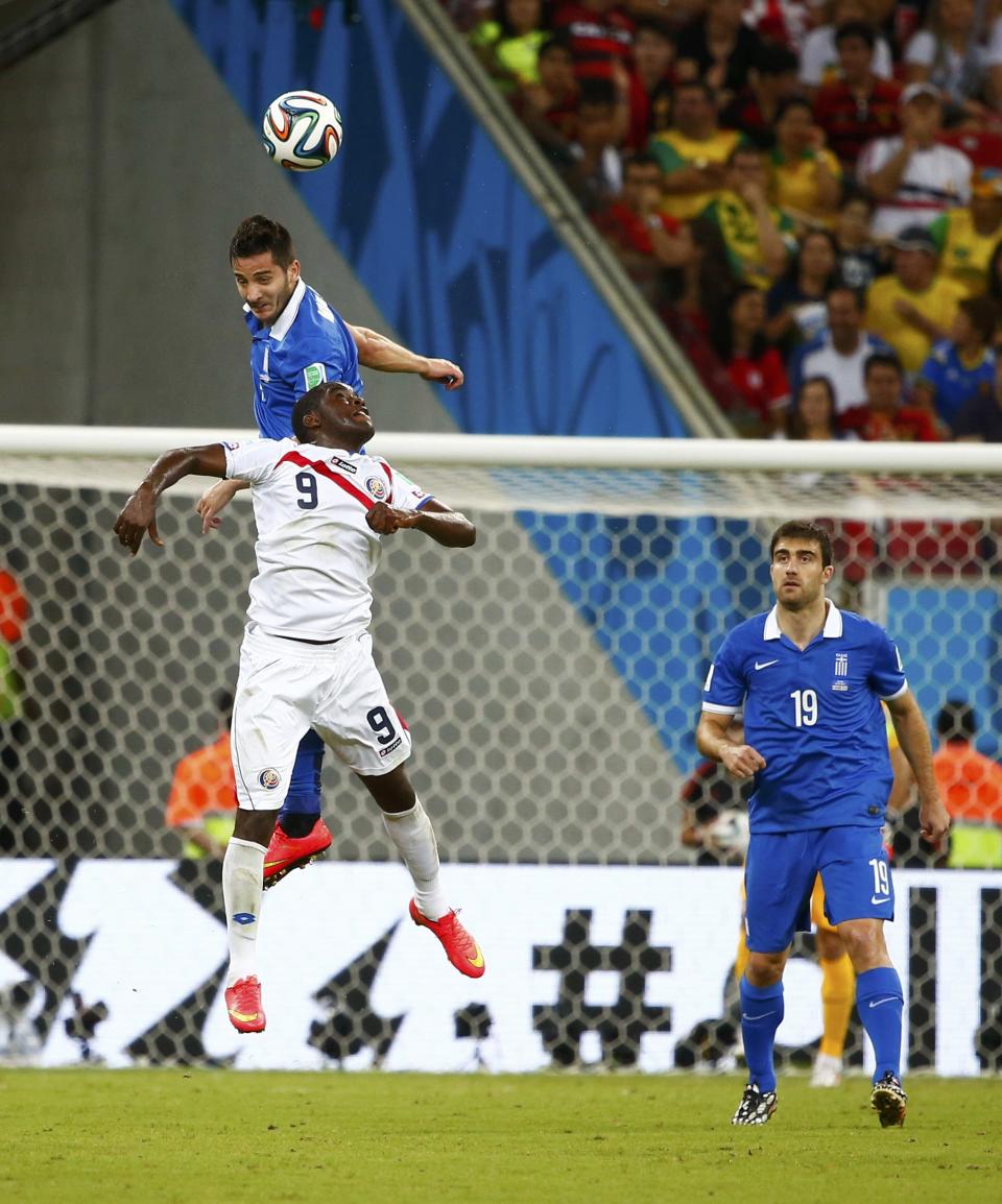 Greece's Kostas Manolas (back) jumps for the ball with Costa Rica's Joel Campbell, next to Greece's Sokratis Papastathopoulos, during their 2014 World Cup round of 16 game at the Pernambuco arena in Recife June 29, 2014. REUTERS/Tony Gentile