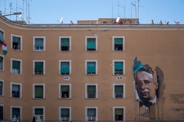 ROME, ITALY - APRIL 25: People stand at their windows and balconies to take part in a 'Liberation Day' flashmob and sing the Italian partizan song 