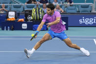 Carlos Alcaraz, of Spain, hits a volley to Lorenzo Musetti, of Italy, during the Miami Open tennis tournament Tuesday, March 26, 2024, in Miami Gardens, Fla. (AP Photo/Marta Lavandier)