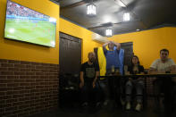 Fans watch the World Cup 2022 qualifying play-off soccer match between Ukraine and Wales at a bar in Kyiv, Ukraine, Sunday, June 5, 2022. (AP Photo/Natacha Pisarenko)