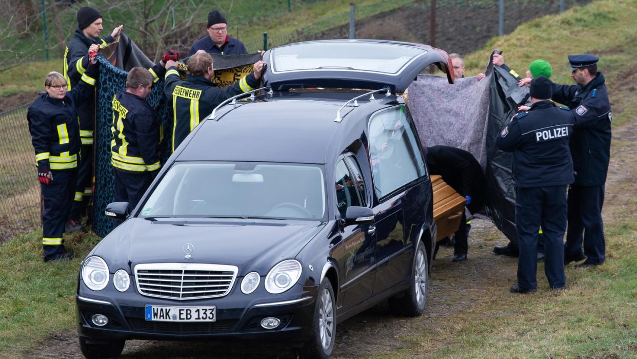 Einsatzkräfte verhindern mit Sichtschutztüchern unerwünschte Blicke.