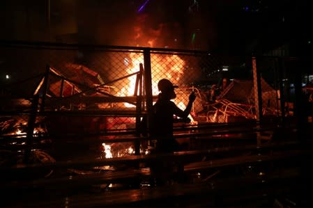 A demonstrator walks past a burning barricade during a protest in Hong Kong