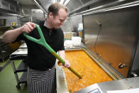 A volunteer chef from the charity 'The Felix Project' stirs a curry at their storage hub in London, Wednesday, May 4, 2022. Across Britain, food banks and community food hubs that helped struggling families, older people and the homeless during the pandemic are now seeing soaring demand. The cost of food and fuel in the U.K. has risen sharply since late last year, with inflation reaching the highest level in 40 years. (AP Photo/Frank Augstein)