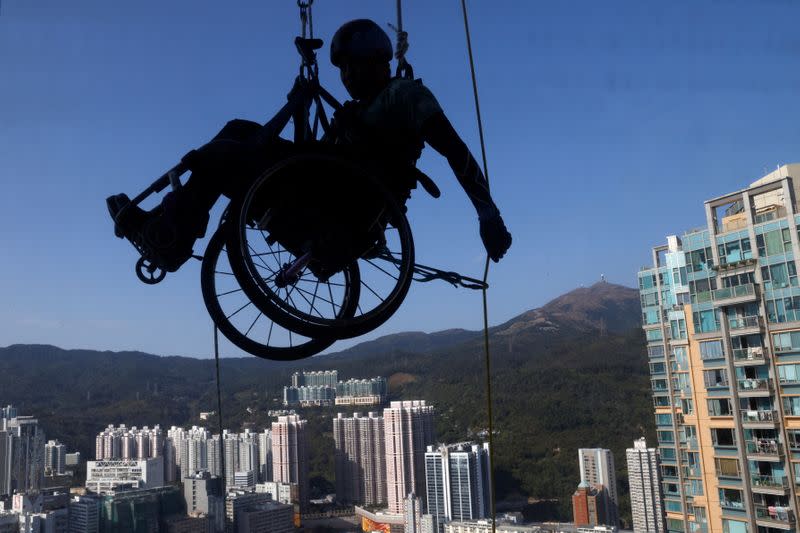 Lai Chi-wai, a paraplegic climber, attempts to climb the 320-metre tall Nina Tower using only his upper body strength, in Hong Kong