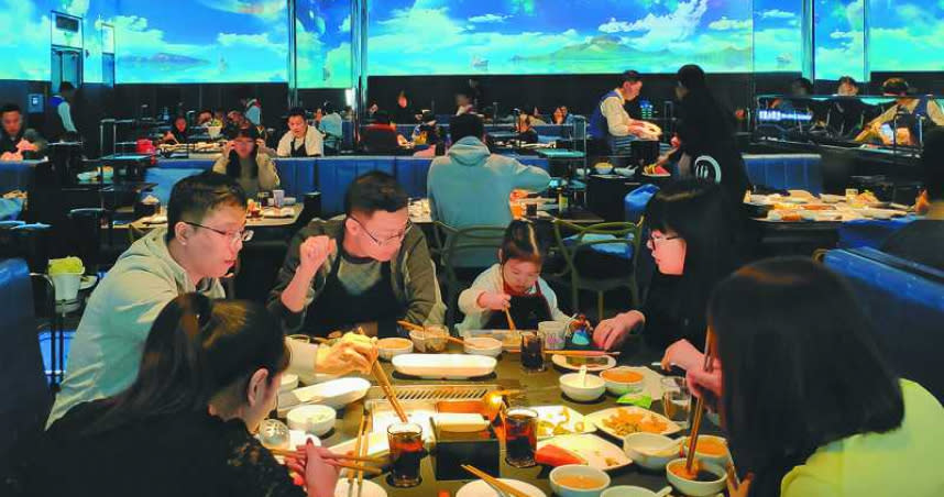 在北京海底撈智慧餐廳，食客們在聲光沉浸式環境中享用火鍋。（圖／新華社資料照片）