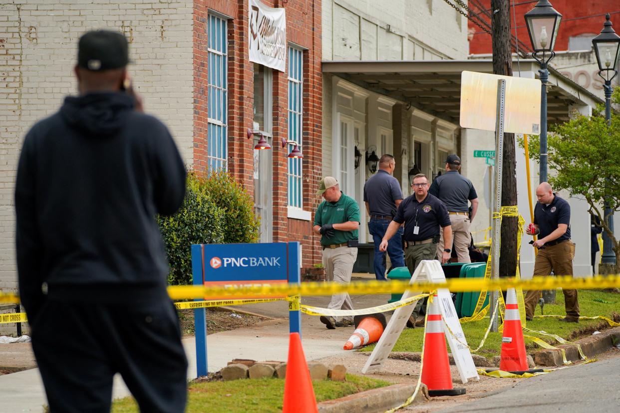 Law enforcement officers walk through the crime scene, a day after the shooting (16 April 2023) (REUTERS)