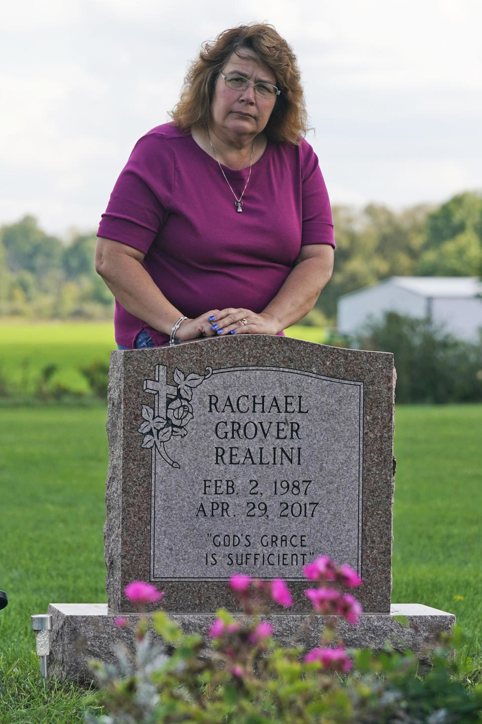 Sharon Grover stands over the grave of her daughter, Rachael, Tuesday, Sept. 28, 2021, at Fairview Cemetery in Mesopotamia, Ohio. Grover believes her daughter started using prescription painkillers around 2013 but missed any signs of her addiction as her daughter, the oldest of five children, remained distanced. Opening statements in what is considered a "bellwether" trial are scheduled for Monday afternoon in federal court in Cleveland. The lawsuits claim the pharmacy chains "created a public nuisance" that has cost each county around $1 billion thus far as the opioid crisis continues unabated.(AP Photo/Tony Dejak)