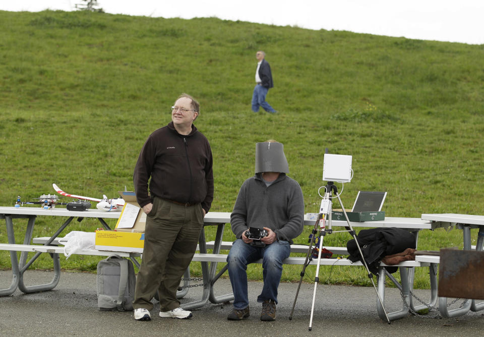 In this March, 28, 2012, photo, Andreas Oesterer, right, uses a video link to fly a drone at a waterfront park as Mark Harrison, left, watches in Berkeley, Calif. Interest in the domestic use of drones is surging among public agencies and private citizens alike, including a thriving subculture of amateur hobbyists, even as the prospect of countless tiny but powerful eyes circling in the skies raises serious privacy concerns. (AP Photo/Eric Risberg)