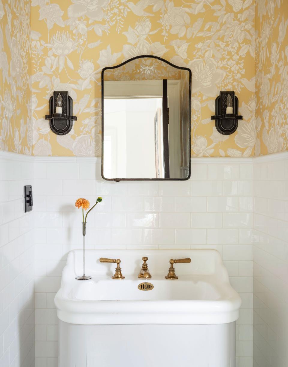 Buttercup yellow wallpaper makes for a particularly sunny powder room.