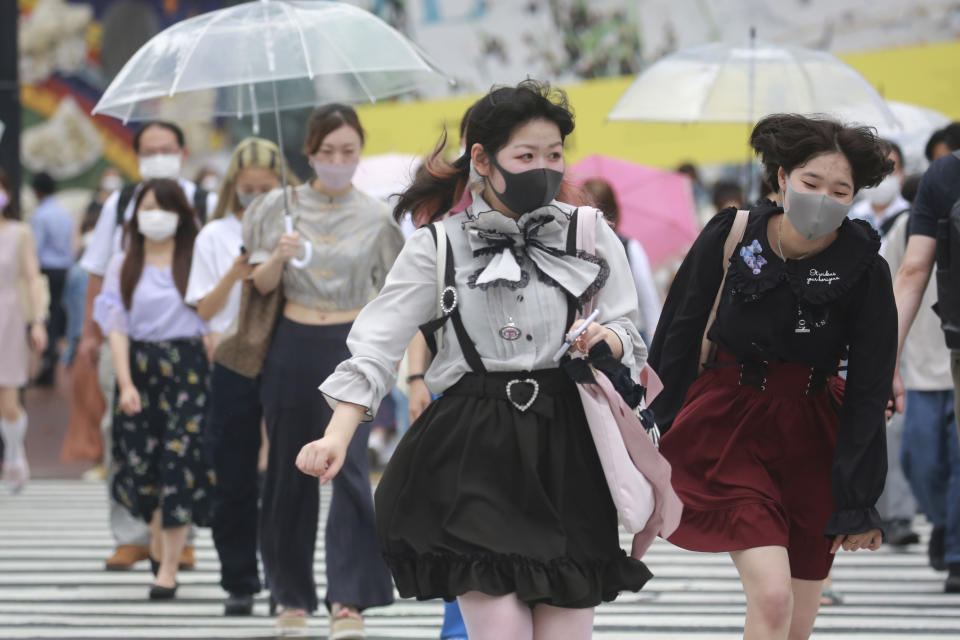 People wearing face masks to protect against the spread of the coronavirus walk on a crossing in Tokyo Tuesday, Aug. 17, 2021. Japan’s coronavirus state of emergency will continue through Sept. 12 rather than finishing at the end of this month as initially planned, the government decided Monday. (AP Photo/Koji Sasahara)