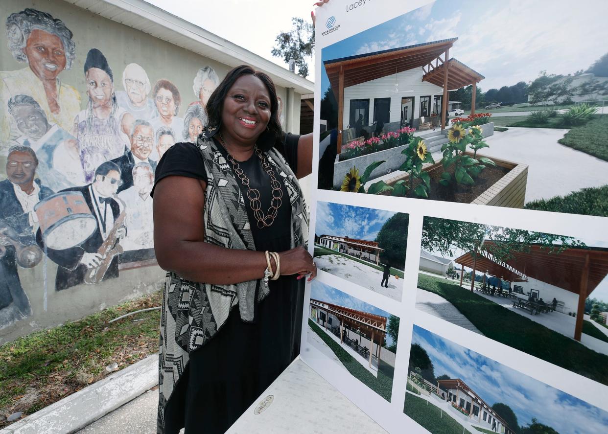 Althea Ross-Chavers, director of the Lacey Family/Spring Hill Boys & Girls Club, shows off renderings of the future center for the club's teens on Wednesday, Nov. 30. The new building, which will replace the one behind her, will bear her name, a gesture that still brings tears to her eyes.