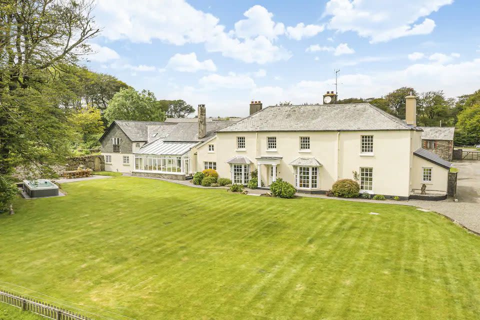 a large white house with a green lawn