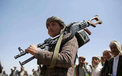 A Shiite Houthi tribesman holds his weapon during a tribal gathering showing support for the Houthi movement, in Sanaa, Yemen - Credit: &nbsp;AP