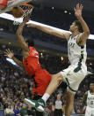 Toronto Raptors' Kawhi Leonard, left, gets fouled on a shot attempt by Milwaukee Bucks' Brook Lopez, right, during the first half of an NBA basketball game, Saturday, Jan. 5, 2019, in Milwaukee. (AP Photo/Aaron Gash)