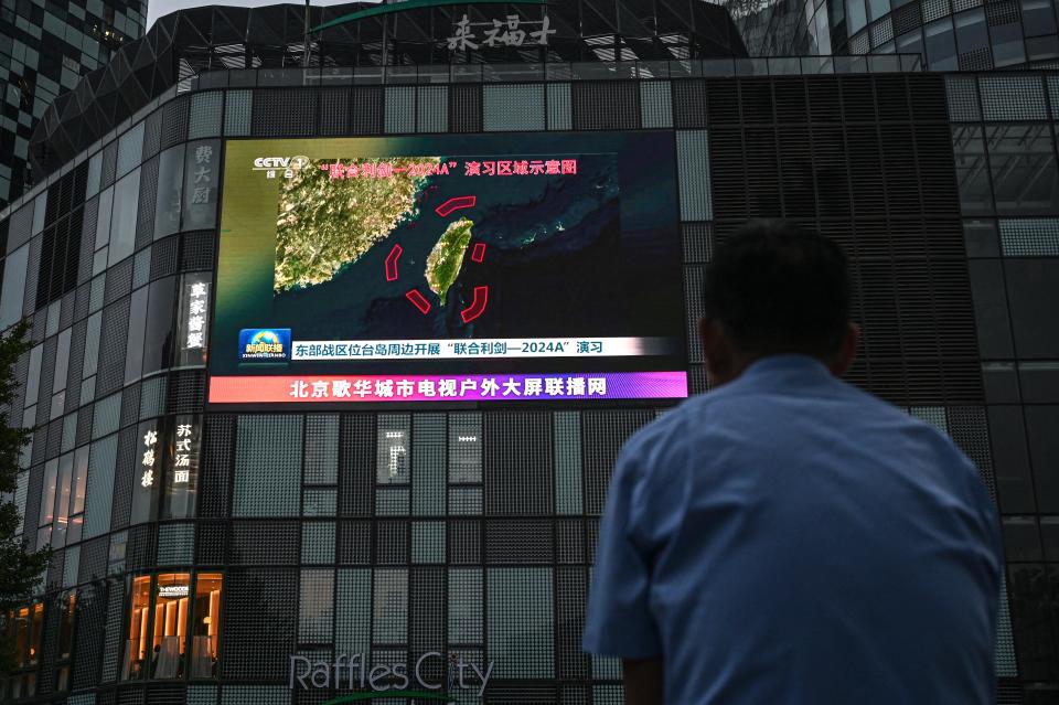 An outdoor screen shows a news coverage of China's military drills around Taiwan, in Beijing on May 23, 2024.