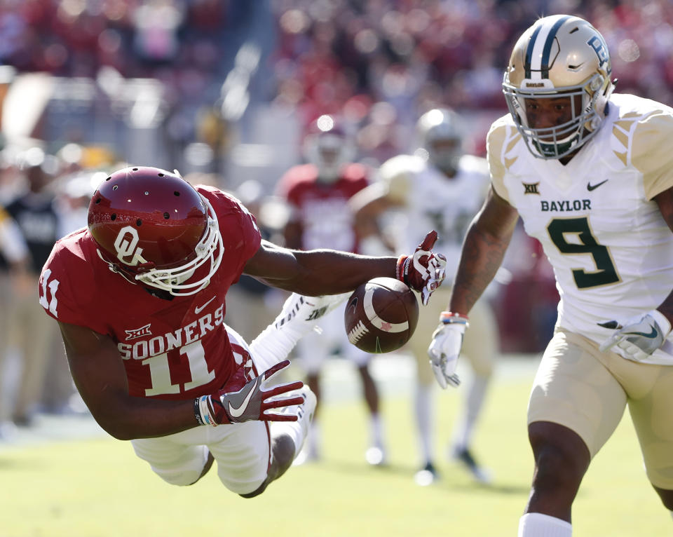 Oklahoma wide receiver Dede Westbrook (11) dives for a catch ahead of Baylor cornerback Ryan Reid (9) during the first half of an NCAA college football game in Norman, Okla. on Nov. 12, 2016. The pass fell incomplete. (Photo: Alonzo Adams/AP)