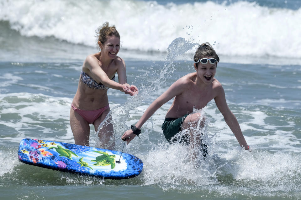 People play in the water at Santa Monica Beach on Wednesday, June 16, 2021, in Santa Monica, Calif. (AP Photo/Ringo H.W. Chiu)
