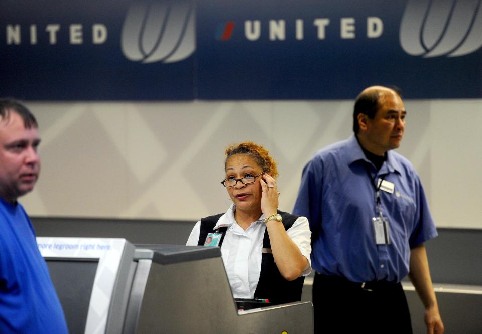 FILE - In this Friday, June 17, 2011, file photo, a United Airlines employee staffs a ticketing counter at San Francisco International Airport, in San Francisco. United Airlines said, Jan. 16, 2014, it will furlough 688 flight attendants after it didn't get enough people to take a voluntary buyout. (AP Photo/Noah Berger, File)
