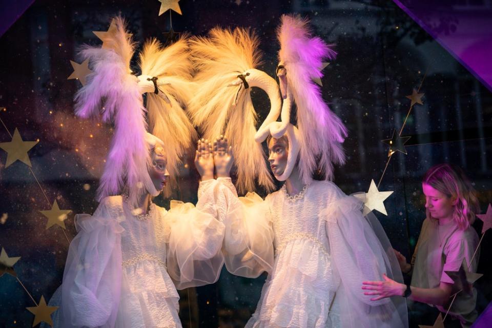 A shop assistant adjusts a window display at Selfridges in London as the department store unveils its 2021 Christmas campaign (Aaron Chown/PA) (PA Wire)