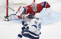 Tampa Bay Lightning's Steven Stamkos (91) scores against Montreal Canadiens goaltender Cayden Primeau, top, during second-period NHL hockey game action in Montreal, Thursday, April 4, 2024. (Graham Hughes/The Canadian Press via AP)