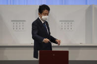 Japan's former Prime Minister Shinzo Abe casts his vote in the Liberal Democrat Party leadership election in Tokyo Wednesday, Sept. 29, 2021. Japan’s former Foreign Minister Fumio Kishida won the governing party leadership election on Wednesday and is set to become the next prime minister, facing the imminent task of addressing a pandemic-hit economy and ensuring a strong alliance with Washington to counter growing regional security risks. (Carl Court/Pool Photo via AP)