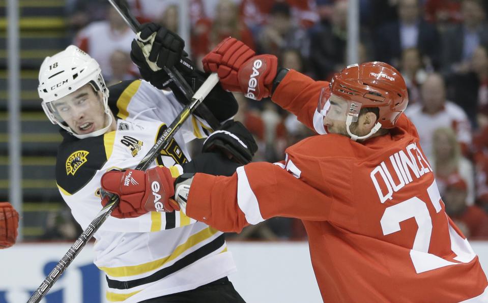 Detroit Red Wings defenseman Kyle Quincey (27) checks Boston Bruins right wing Reilly Smith during the first period of Game 4 of a first-round NHL hockey playoff series in Detroit, Thursday, April 24, 2014. (AP Photo/Carlos Osorio)