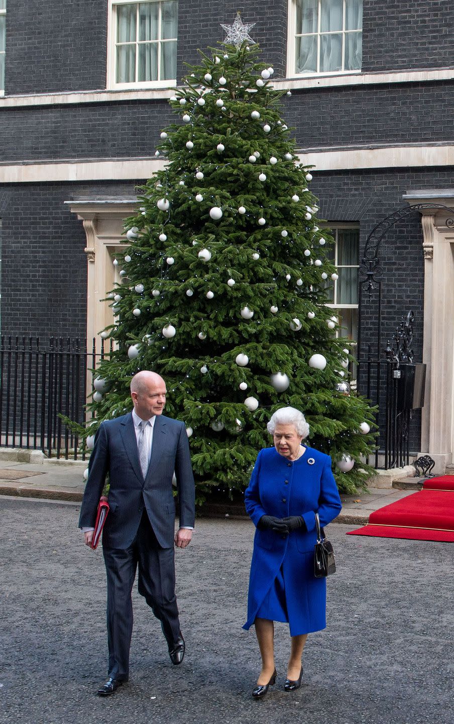 <p>Looking beautiful in blue, Queen Elizabeth departs a cabinet meeting in London with Foreign Secretary William Hague.</p>