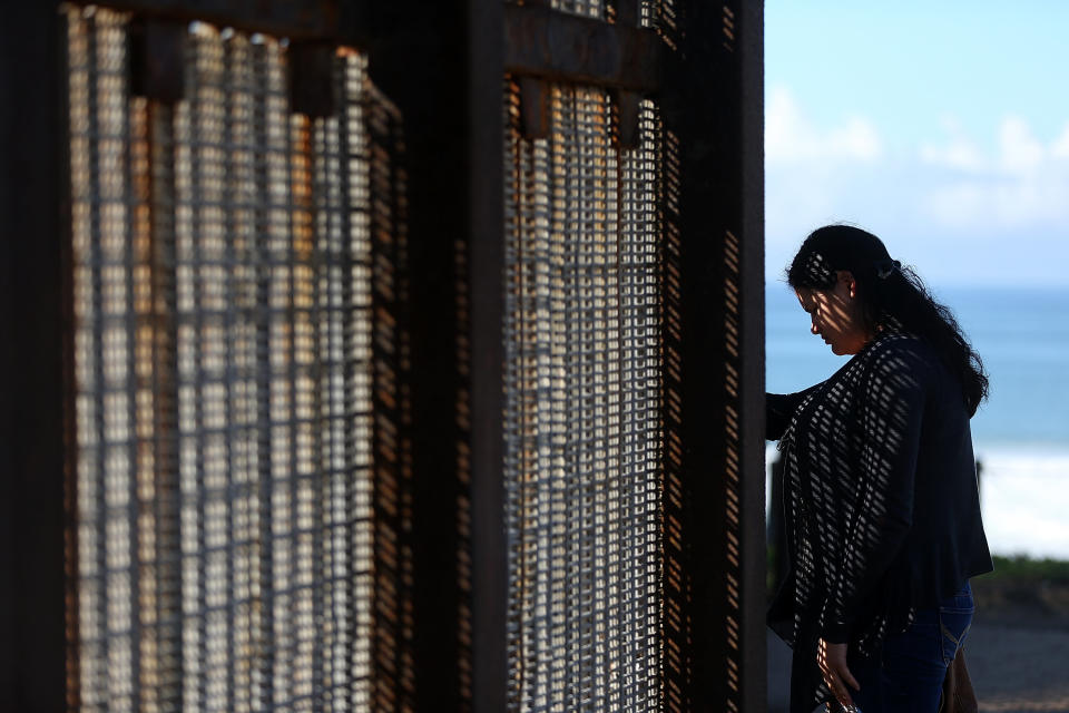 A visitor stands next to the U.S.-Mexico border fence at Friends of Friendship Park in San Ysidro, California.