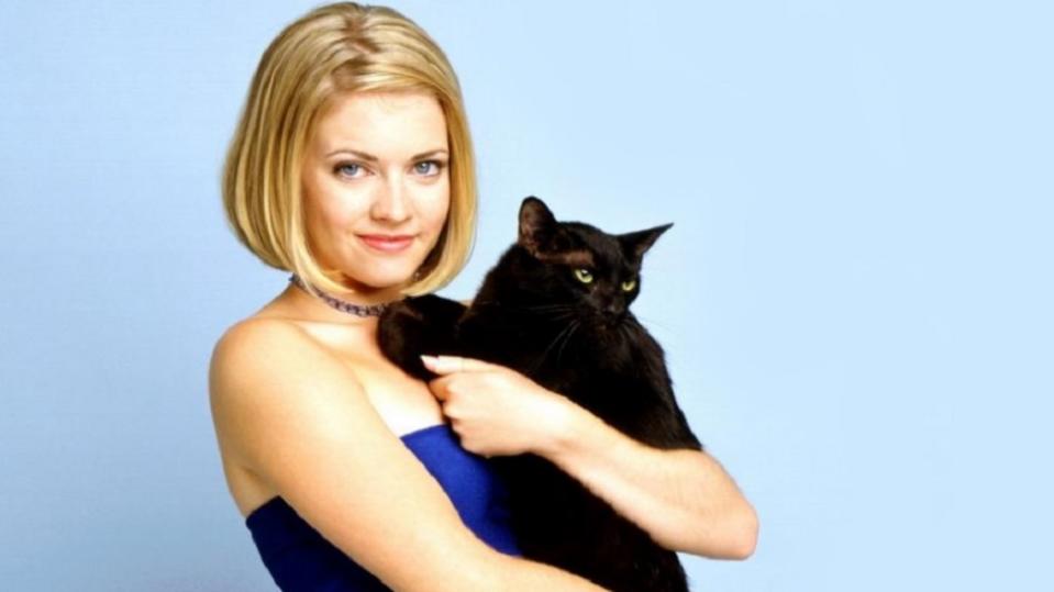 Sabrina the Teenage Witch hugs her cat Salem