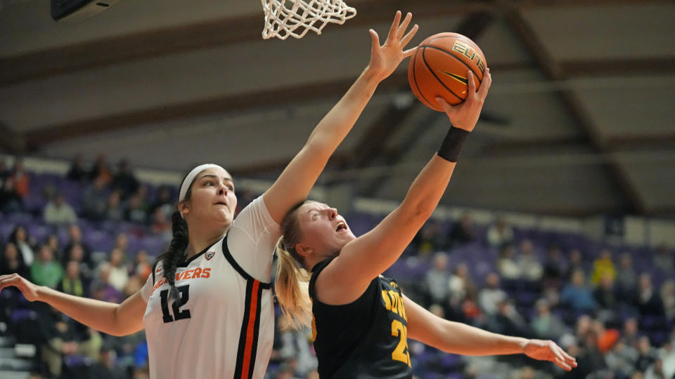 Oregon State forward Jelena Mitrovic (12) defends as Iowa forward Monika Czinano, right, goes to the basket during the first half of an NCAA college basketball game in the Phil Knight Legacy tournament Friday, Nov. 25, 2022, in Portland, Ore. (AP Photo/Rick Bowmer)