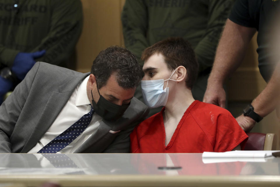 Parkland school shooter Nikolas Cruz, right, speaks to defense attorney Gabe Ermine during a pre-trial hearing at the Broward County Courthouse in Fort Lauderdale, Fla., Wednesday, July 14, 2021, on four criminal counts stemming from his alleged attack on a Broward jail guard in November 2018. Cruz is accused of punching Sgt. Ray Beltran, wrestling him to the ground and taking his stun gun. (Amy Beth Bennett/South Florida Sun-Sentinel via AP, Pool)