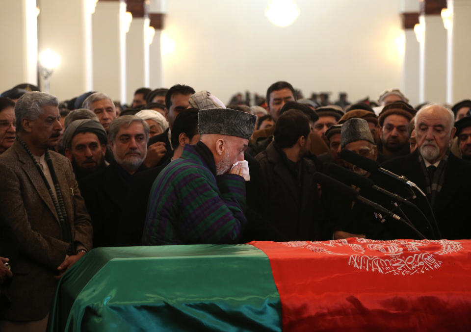 Afghan President Hamid Karzai, center, attends the funeral procession of Afghanistan's influential Vice President Mohammad Qasim Fahim in Kabul, Afghanistan, Tuesday, March 11, 2014. Fahim, a leading commander in the alliance that fought the Taliban who was later accused with other warlords of targeting civilian areas during the country's civil war, died on Sunday, March 9, 2014. He was 57. (AP Photo/Rahmat Gul)