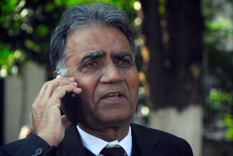 Akhtar Shah, lawyer of former military ruler Pervez Musharraf, talks on the phone outside special court in Islamabad