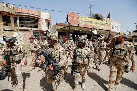 Iraqi army soldiers walk with their weapons in center of Falluja, Iraq, June 17, 2016. REUTERS/Thaier Al-Sudani TPX IMAGES OF THE DAY