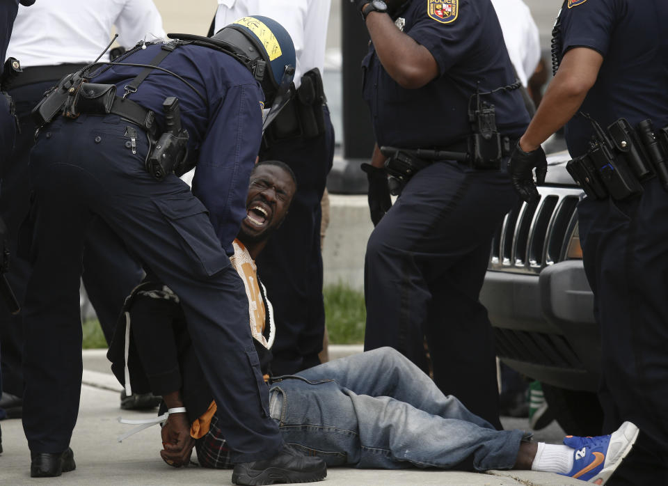 Baltimore Police officers arrest a man near Mowdamin Mall, April 27, 2015 in Baltimore, Maryland. The funeral service for Freddie Gray, who died last week while in Baltimore Police custody, was held on Monday morning. (Photo by Drew Angerer/Getty Images)