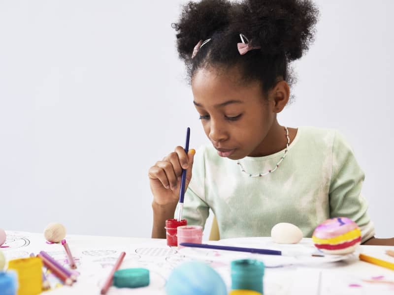 Minimal portrait of cute black girl enjoying art and craft class on Easter, copy space