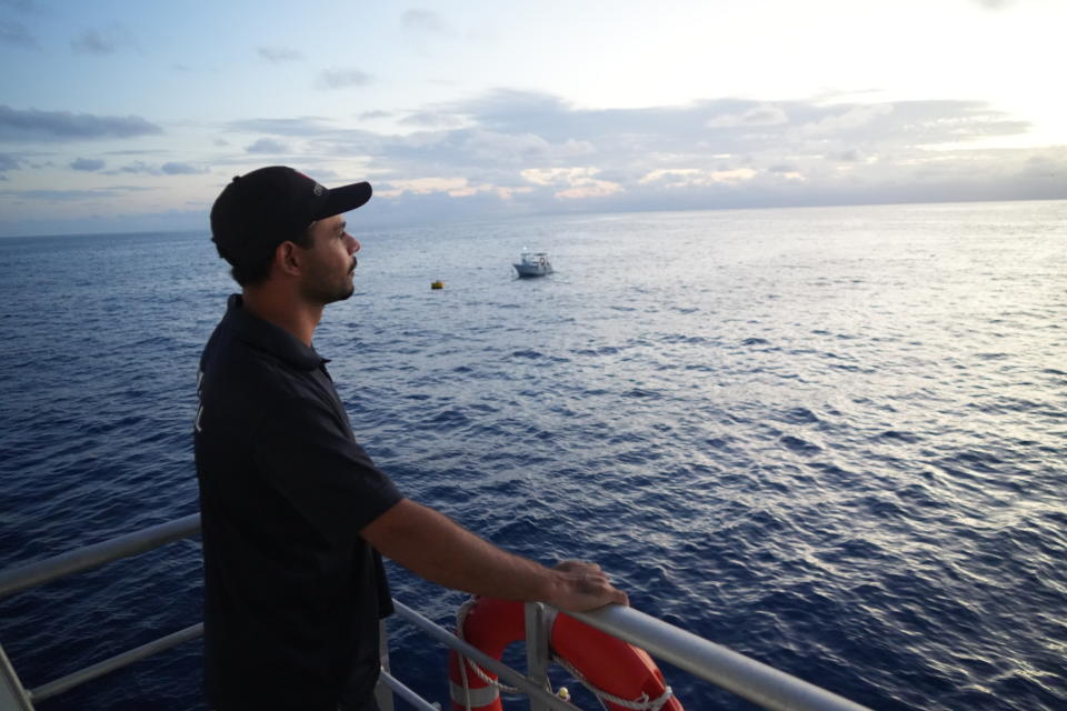 Tarquin Singleton, cultural officer at the Reef Cooperative, stands on the Remoora pontoon above a section of the Great Barrier Reef in Gunggandji Sea Country off the coast of Queensland in eastern Australia on Nov. 15, 2022. Singleton is from the Yirrganydji community which has partnered with authorities to protect the Great Barrier Reef. (AP Photo/Sam McNeil)