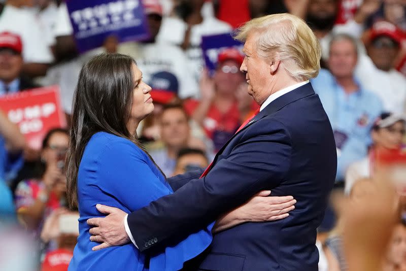 U.S. President Donald Trump and press secretary Sarah Sanders hug at a campaign kick off rally at the Amway Center in Orlando