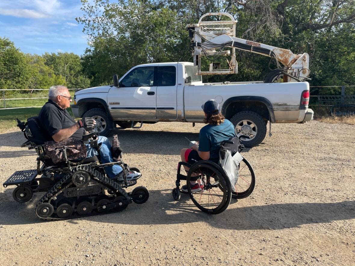 Retired Saskatchewan farmer Merle Malin, left, gifts Levi Jamieson a hydraulic lift to help him get into equipment on the farm.  (Submitted by Diane Jamieson - image credit)