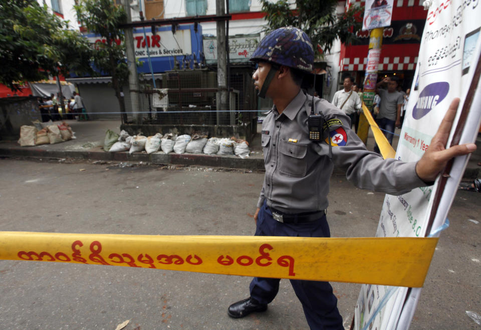 A Myanmar policeman stands guard at a restricted area after a bomb squad found a suspicious looking packet, in downtown Yangon, Myanmar, Tuesday, Oct. 15, 2013. Police urged vigilance after several small bombs exploded in and around Myanmar's largest city of Yangon in recent days. No one claimed responsibility for the boasts and it was not immediately clear if they were related. (AP Photo/Khin Maung Win)