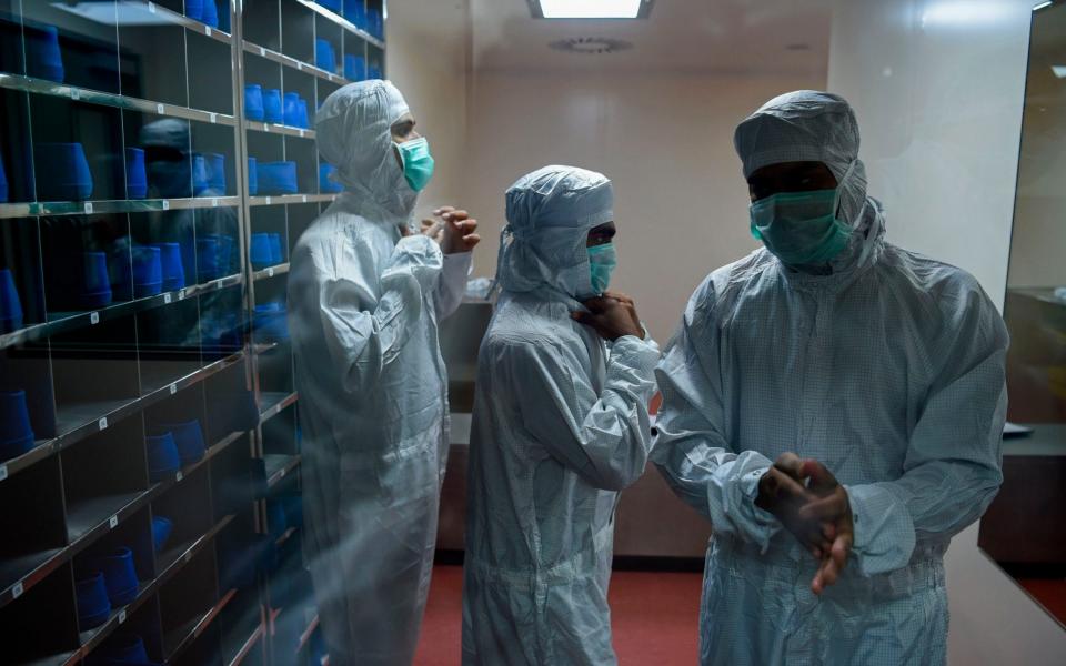 Employees prepare themselves before getting inside a lab where Covishield, AstraZeneca-Oxford's coronavirus vaccine is being manufactured, at India's Serum Institute - PUNIT PARANJPE/AFP via Getty Images