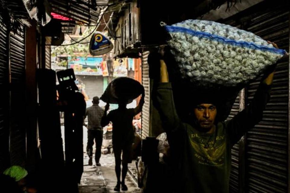 A worker carries a sack of garlic as he crosses an alley (AFP/Getty)