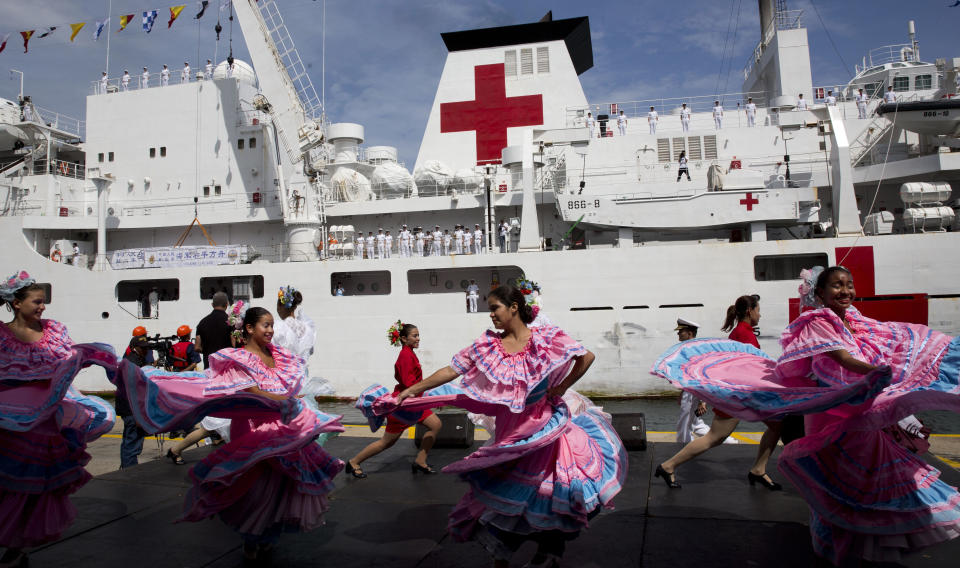 Venezuelan dancers welcome the arrival of Chinese navy hospital ship " The Peace Ark" docked at the port in la Guaira, Venezuela, Saturday, Sept. 22, 2018. The stop by the People's Liberation Army Navy's ship is the latest in an 11-nation "Mission Harmony" tour and will provide free medical treatment for Venezuelans. (AP Photo/Ariana Cubillos)