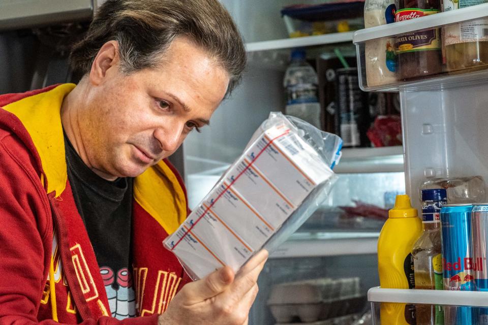 Travis Paulson looks at insulin drugs that he keeps in his refrigerator on January 16, 2020 in Eveleth, Minnesota. (Photo by Kerem Yucel/AFP)