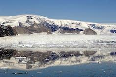 Antarctic glacier remains of the melting Larsen A ice shelf in front of mountains.