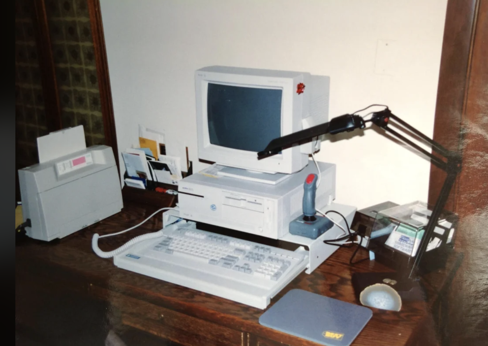 Reddit post by u/nostalgia with an image of a 1990s computer setup. The image includes a monitor, keyboard, printer, joystick, and floppy disks on a desk