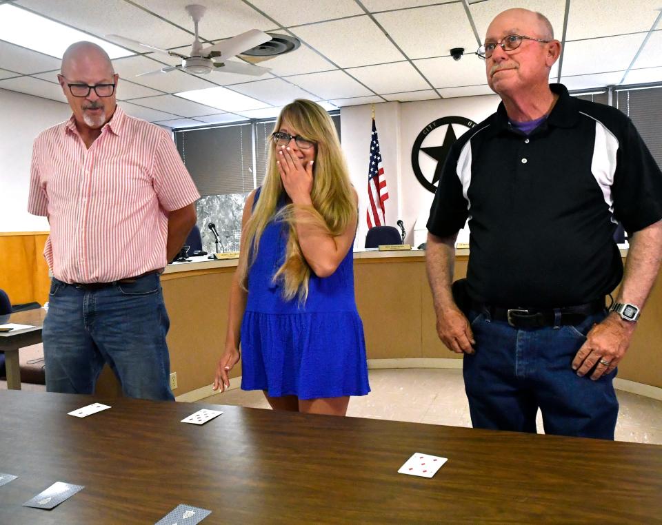 Katherine Bushart reacts after drawing the winning card in the three-way lottery for a position on the Stamford City Council on Thursday. She and her opponents Jay Webb (left) and Morgan Campbell had evenly split the vote in the May 6 election and agreed to draw cards at City Hall to decide the winner.