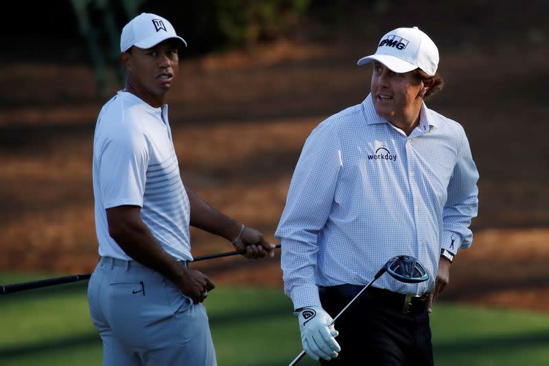 FILE PHOTO: U.S. golfers Woods and Mickelson walk to the 11th tee during practice for the 2018 Masters golf tournament in Augusta