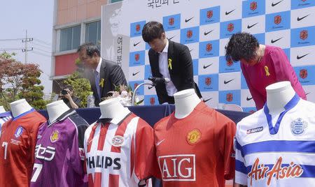 South Korean soccer player Park Ji-sung (C) and his parents bow during a news conference to announce his retirement in Suwon May 14, 2014. REUTERS/Lee Dong-won/News1
